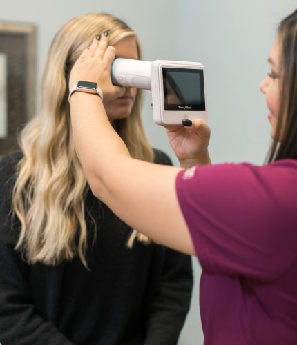 nurse examines patient's eye with tool